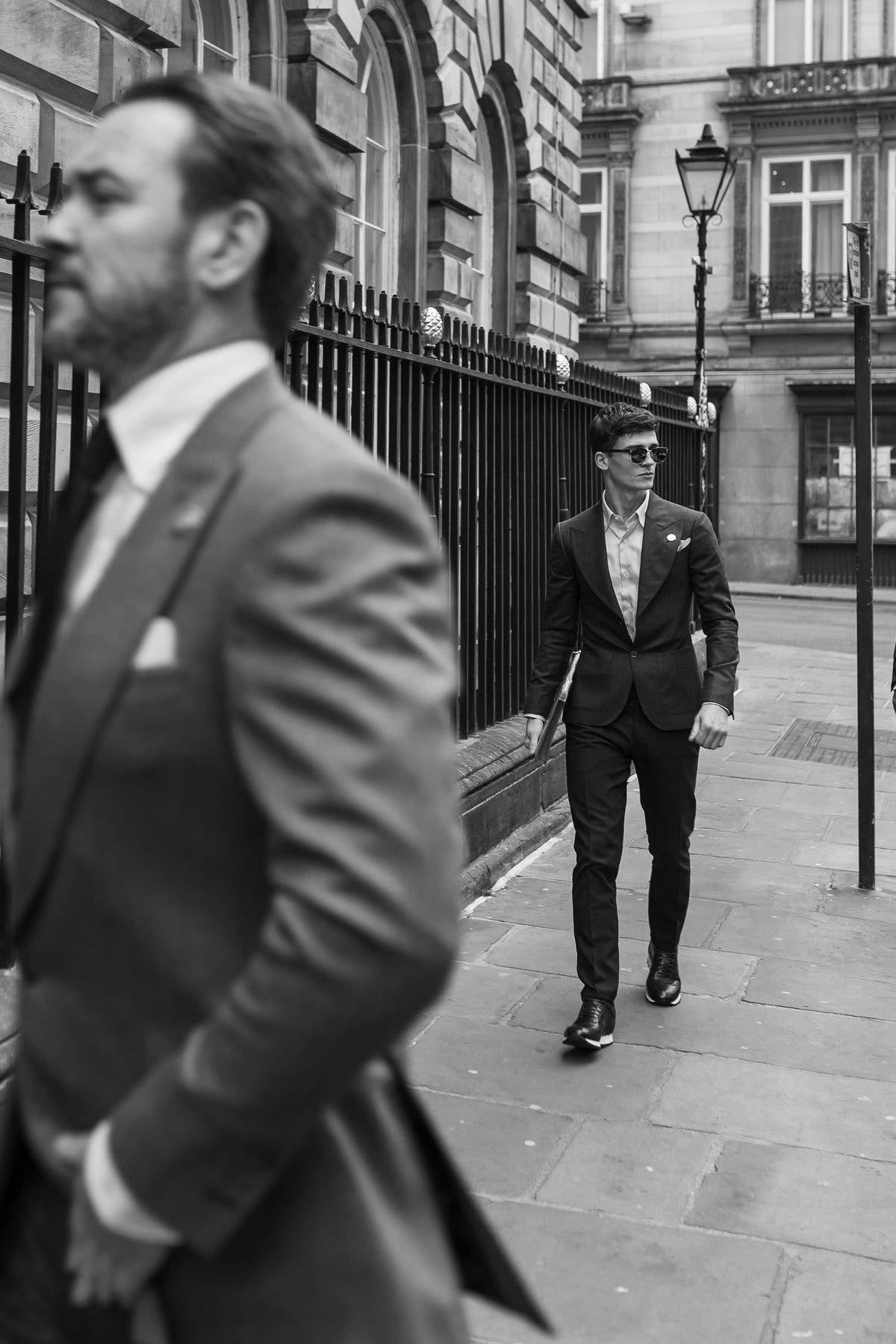 Two men in tailored suits walking through a city street