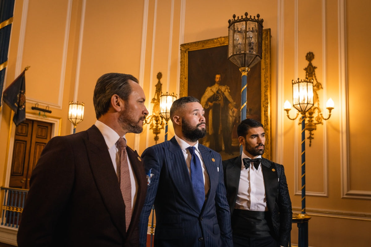Three men in bespoke suits and eveningwear in a formal hall