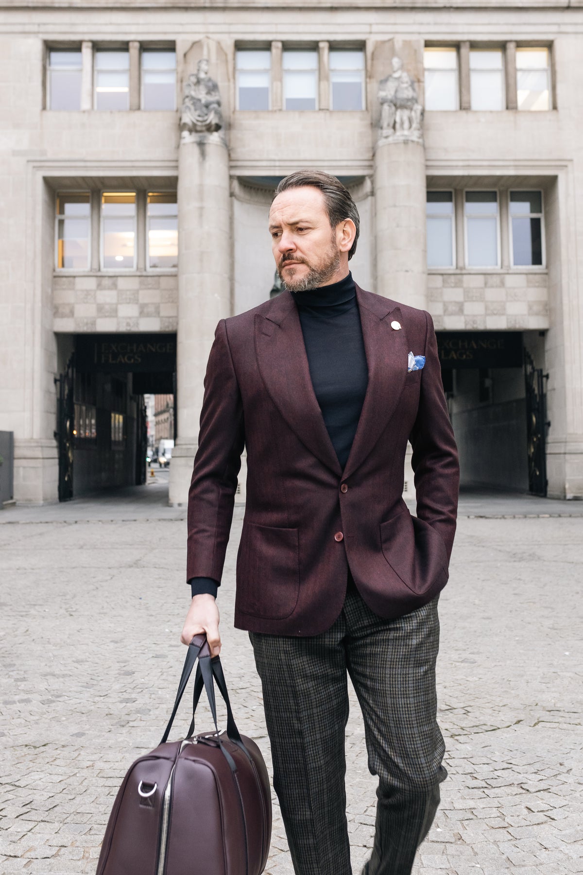 A client in burgundy bespoke tailoring arriving for a private appointment